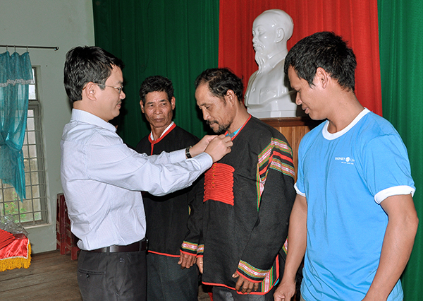 Phó Giám đốc Sở Văn hóa, Thể thao và Du lịch Đặng Gia Duẩn trao trang phục truyền thống cho các nghệ nhân tham gia truyền dạy