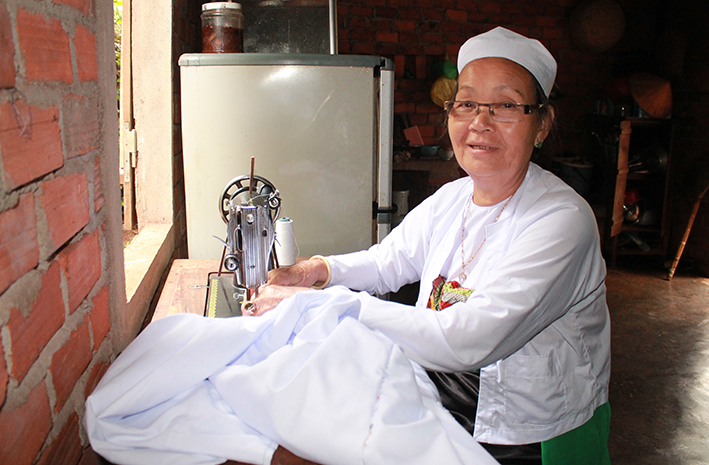 Nghệ nhân Nguyễn Thị Lộc may trang phục truyền thống của người Mường.