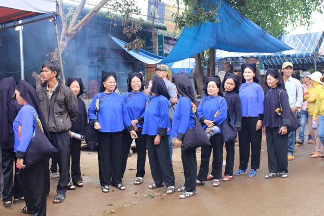 Từng tốp phụ nữ người Nùng với trang phục truyền thống cùng nhau đi tới nơi tổ chức lễ hội Hảng Pồ.