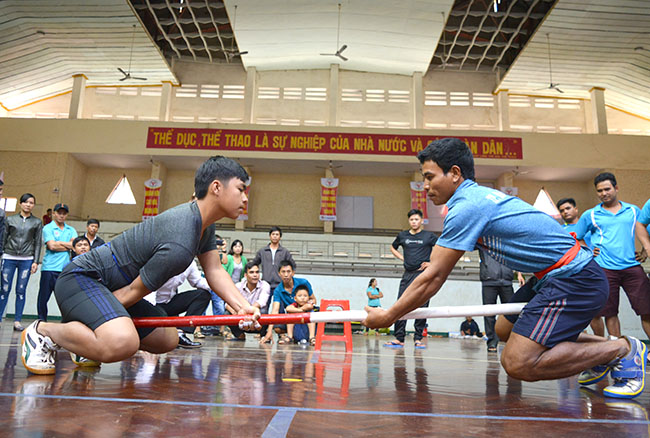 Vận động viên thị xã Buôn Hồ Huỳnh Thanh Vỹ (bên trái) thi đấu chung kết môn đẩy gậy.