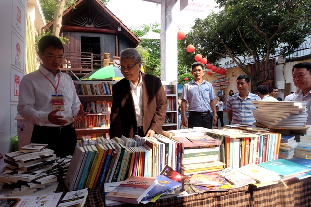 Phó Giám đốc Sở Văn hóa, Thể thao và Du lịch Đặng Gia Duẩn giới thiệu với nguyên Chủ tịch nước về không gian sách cộng đồng tại Đường sách