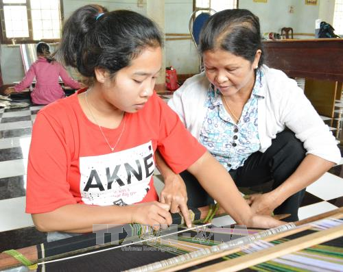 Bà H’Jih Ayun (bên phải) dạy nghề dệt thổ cẩm cho các học viên.