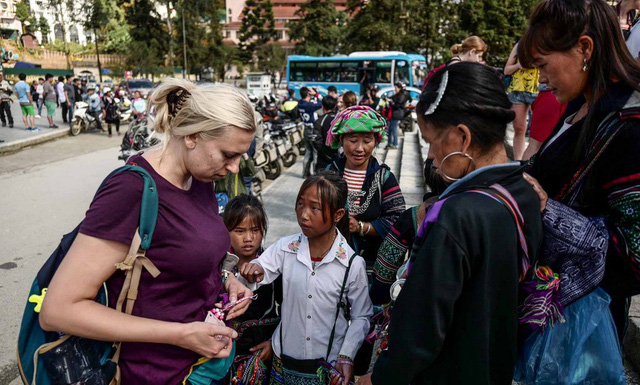 Một khách du lịch nước ngoài tại Sa Pa bị "bủa vây" bởi các em bé bán đồ lưu niệm - Ảnh: NGUYỄN KHÁNH
