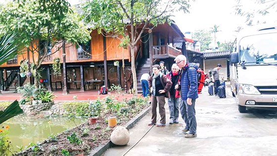 Du khách nước ngoài tham gia mô hình du lịch cộng đồng ở xã Nghĩa Lợi. 