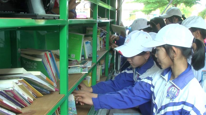 Học sinh Trường THCS Nguyễn Đức Cảnh (xã Ea Kmút, huyện Ea Kar) lựa chọn sách tại xe ô tô thư viện lưu động-Ảnh minh họa