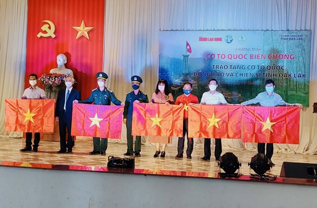 Đại diện Lãnh đạo UBND tỉnh Đắk Lắk và Báo Người Lao Động trao cờ tặng cán bộ chiến sĩ và nhân dân vùng biên giới