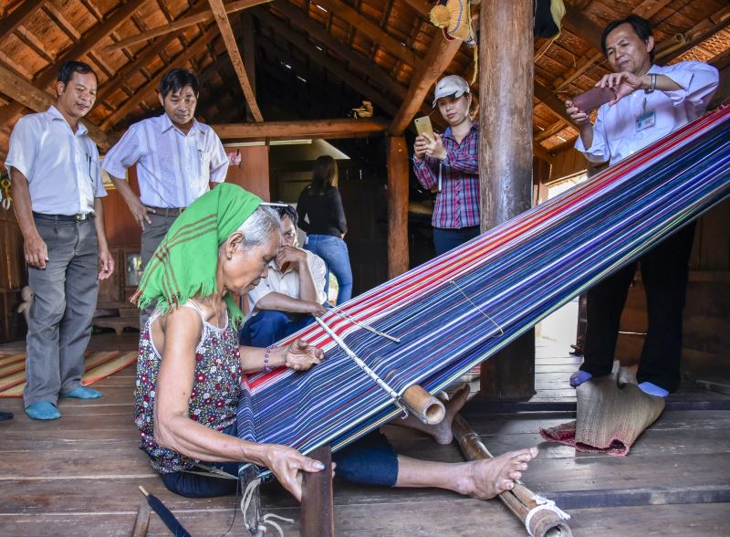 Du khách tham quan tìm hiểu về dệt thổ cẩm truyền thống tại buôn Ko Dhong, thành phố Buôn Ma Thuột
