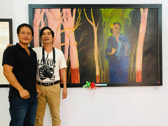 Họa sĩ Hồ Hậu (bên trái) bên tác phẩm "Giấc mơ màu xanh" tại Triển lãm Mỹ thuật khu vực V – Nam miền Trung và Tây Nguyên 2019.
