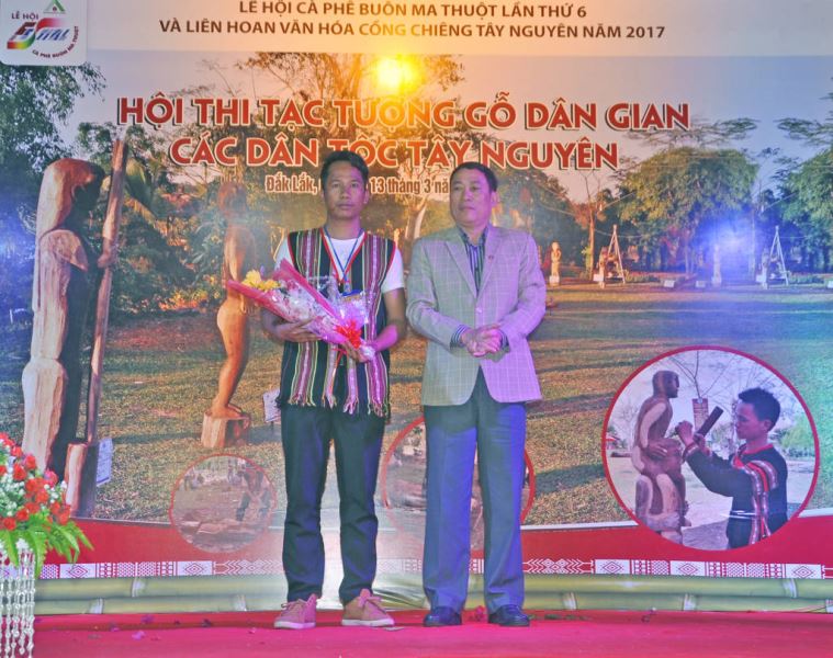 Phó Chủ tịch UBND tỉnh, Trưởng Ban Tổ chức Hội thi - Võ Văn Cảnh tặng hoa chúc mừng nghệ nhân Y Ân B’Ja (Đắk Nông) người đạt giải Nhất Hội thi.